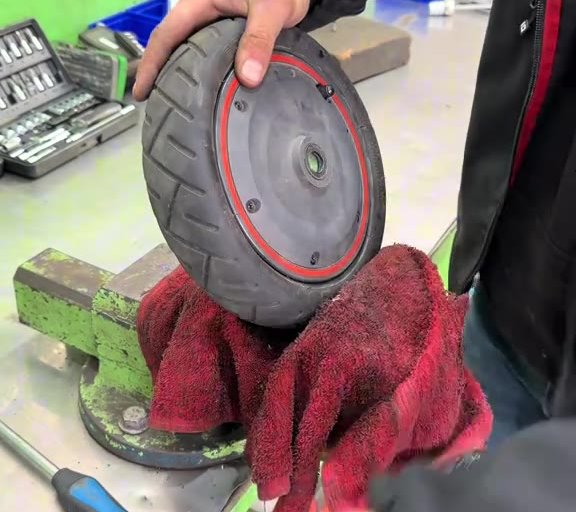 Ausgebautes E-Scooter-Rad im Schraubstock