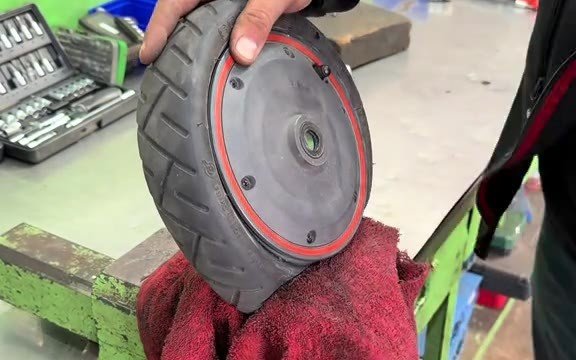 Ausgebautes E-Scooter-Rad im Schraubstock